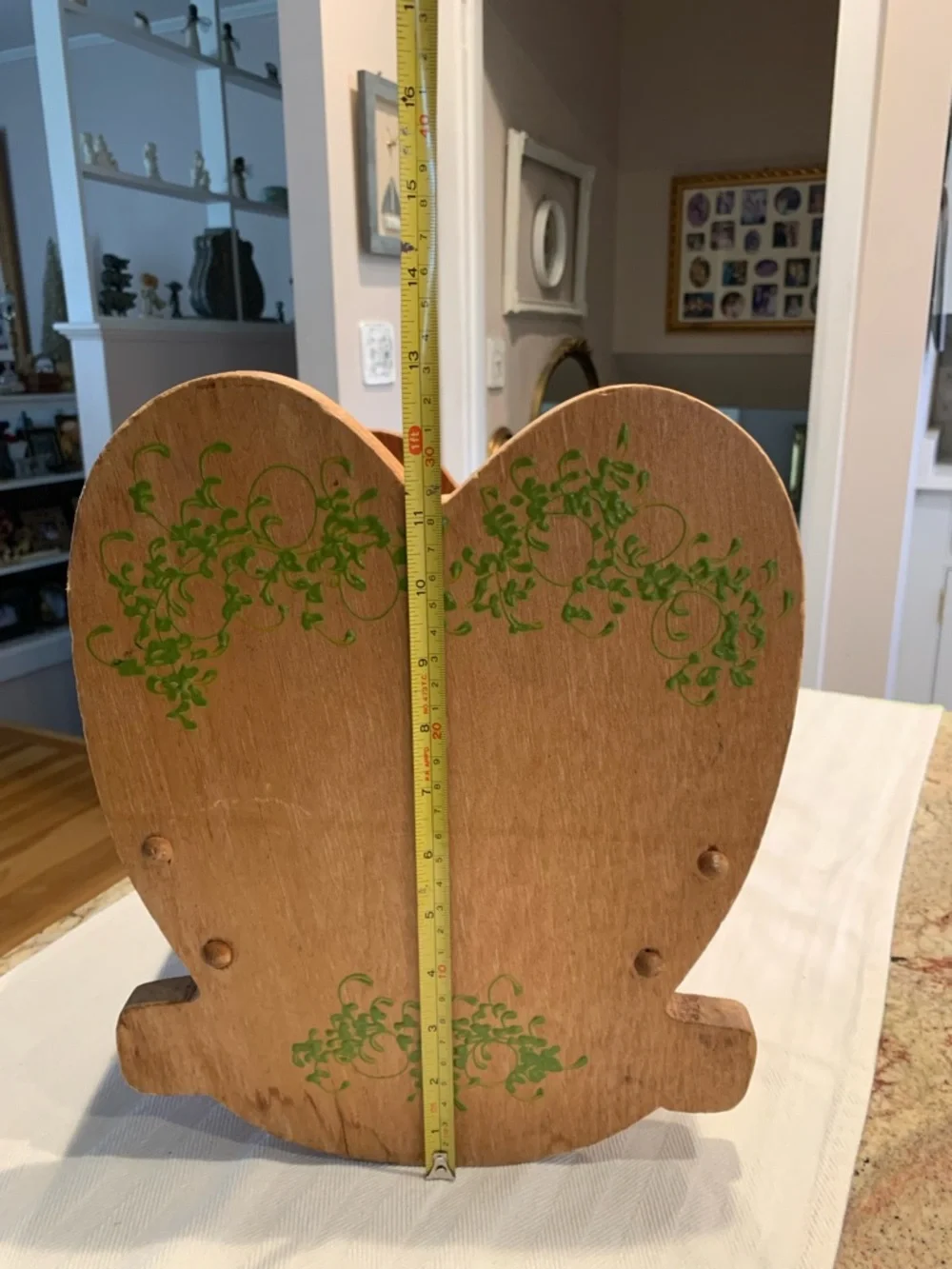 Vintage wooden doll cradle heart-shaped design painted with floral details.